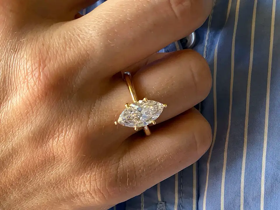Handmade gold ring with marquise diamonds, worn on a hand