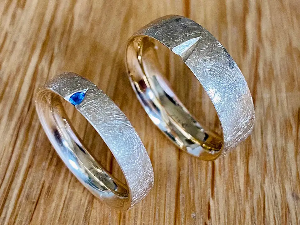 Two handmade textured gold rings, one set with a blue sapphire