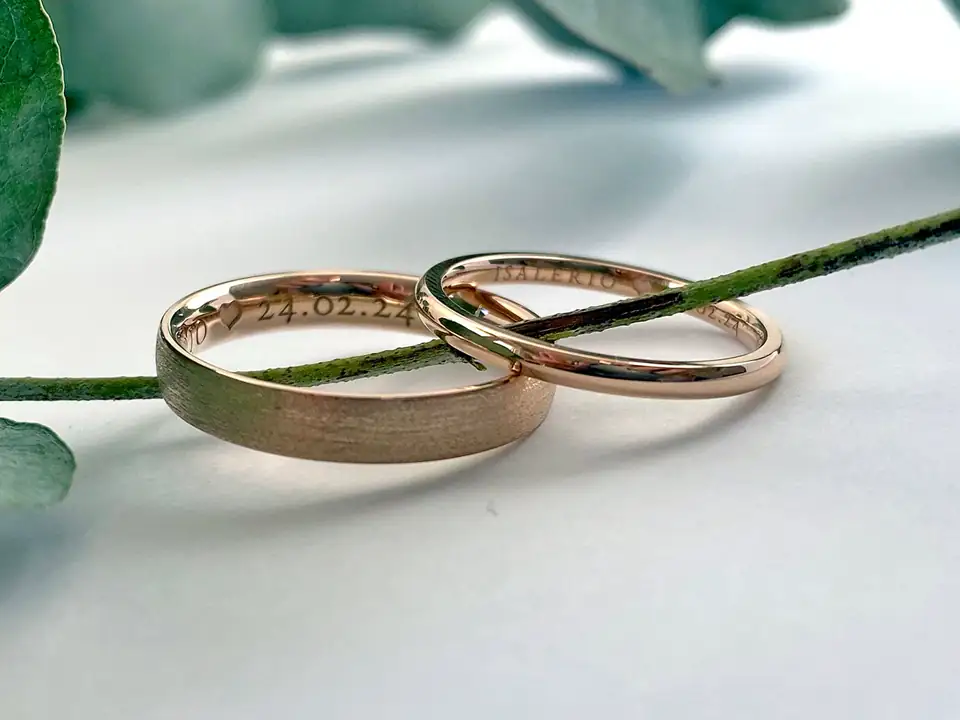 Two slim rose-gold wedding bands, one matte and one polished